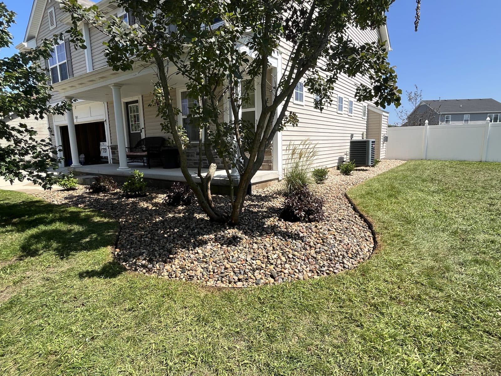 Tree-ring rock bed with a clean cut edge by Meeks Mowing & Landscaping